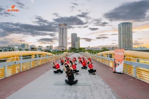 Alpha members enjoying an outdoor yoga session at Nguyen Van Troi Bridge ahead of Vietnam National Day 2026.